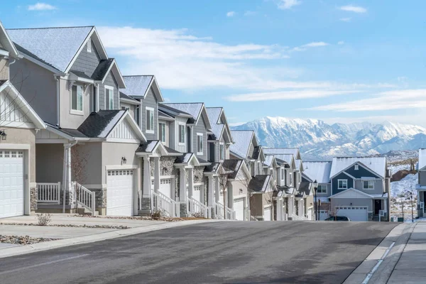 Camino en un paisaje de barrio suburbano con casas contra la montaña y el cielo — Foto de Stock