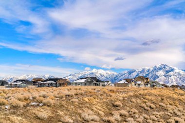 Karlı Wasatch Dağları manzaralı geniş çimenli arazide evler