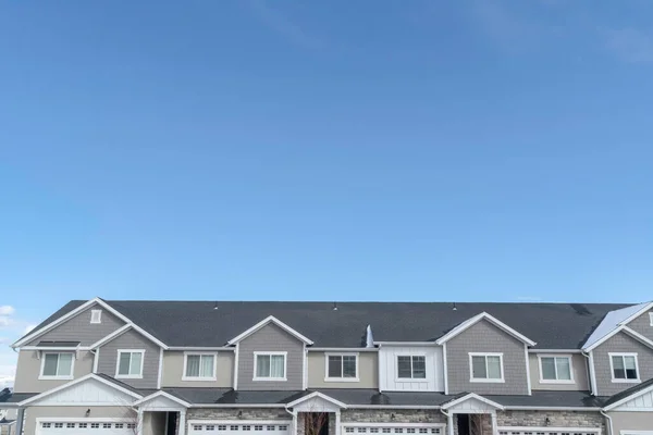 Верхній поверх заміських будинків з сірими дахами і гуртожитками на тлі блакитного неба — стокове фото