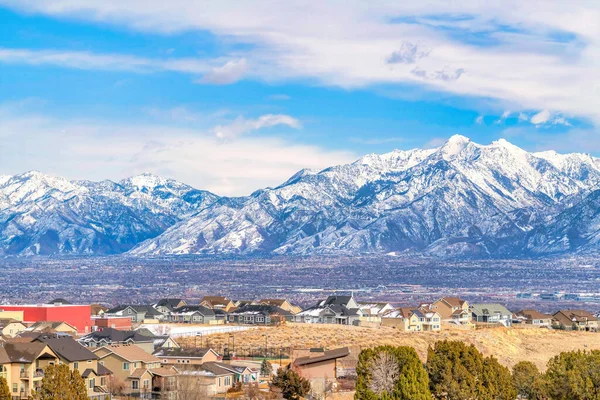 Magnífico nevado Wasatch Mountain se eleva sobre un barrio y valle — Foto de Stock