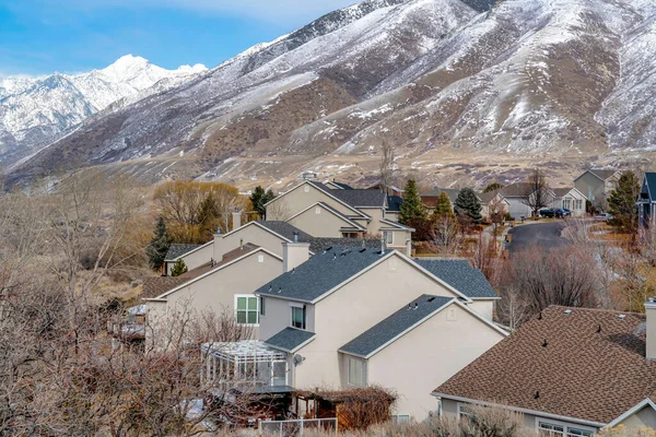 Casas en un paisaje de vecindario de invierno con fondo nevado de ladera de montaña — Foto de Stock