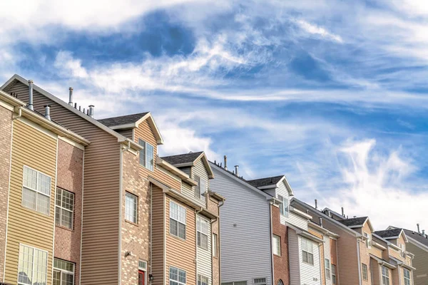 Vista exterior de casas adosadas contra paisaje escénico de cielo azul y nubes — Foto de Stock
