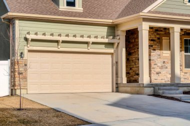 Güneşli bir günde evin garaj girişine odaklı emlak manzarası