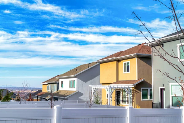 Casas de dos pisos con vistas al valle bajo nubes brillantes y cielo azul — Foto de Stock