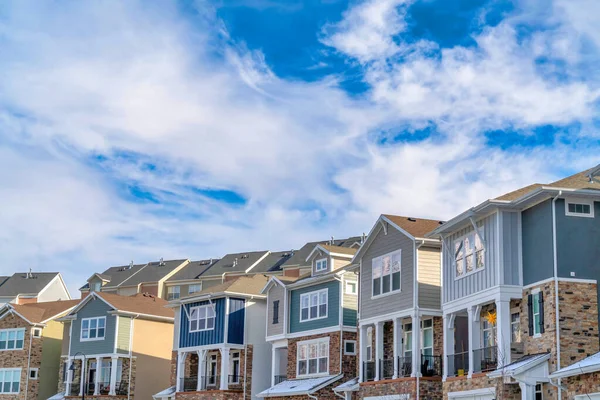 Casas en el valle en un día soleado bajo el cielo azul vibrante y las nubes — Foto de Stock