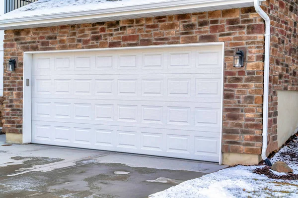 Puerta de garaje de madera blanca y entrada húmeda del hogar con patio cubierto de nieve en invierno — Foto de Stock