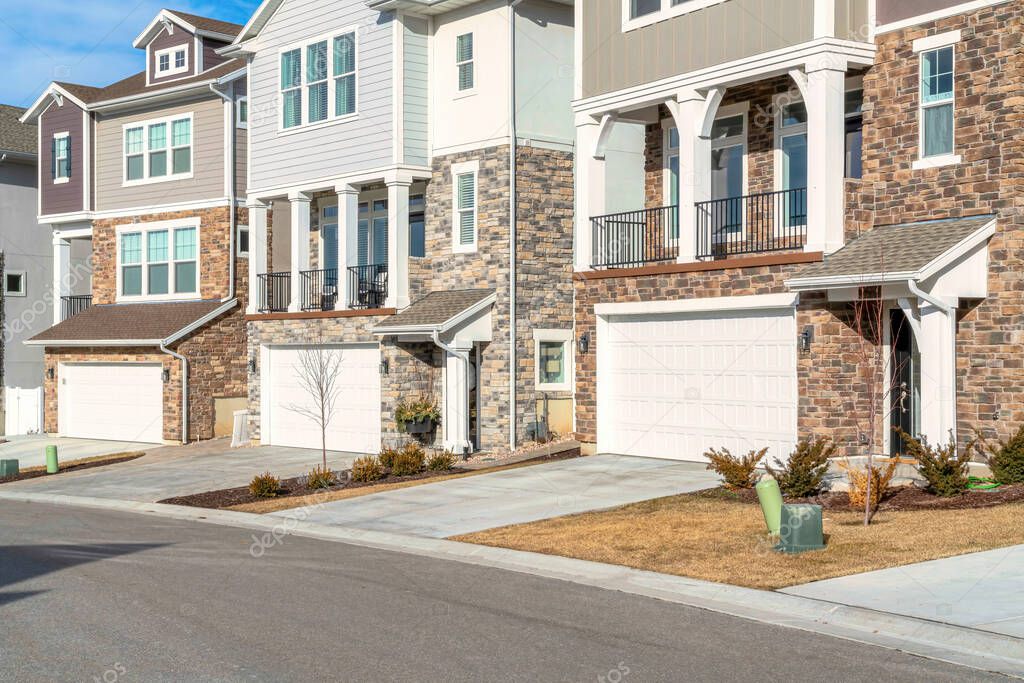 Three storey homes with attached garages and balconies overlooking the road