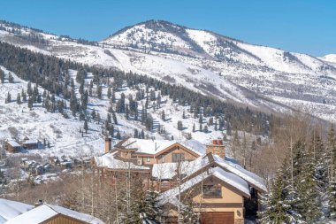 Park City Utah 'ta karla kaplı dağ manzaralı evler.