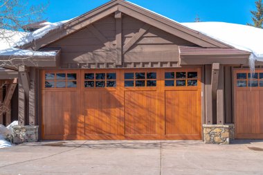 Park City Uta 'daki evinin güneşli dış cephesinde cam camlı kahverengi garaj kapısı var.