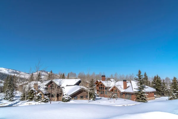 Cielo azul vivo sobre la montaña en Park City Utah con casas en medio de terreno nevado — Foto de Stock