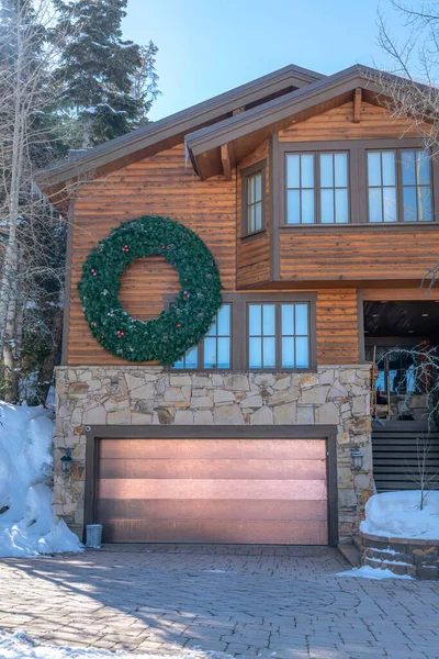 Home in Park City Utah with huge wreath over the garage door against blue sky