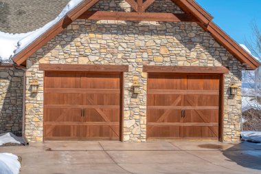 Park City 'deki ev garajında ahşap kapılar ve çatı altında taş duvarlar var.