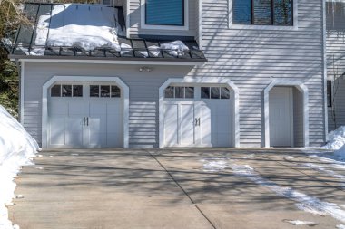 Park City mahallesinde beyaz duvarı olan bir evin garaj kapısı ve ön kapısı.