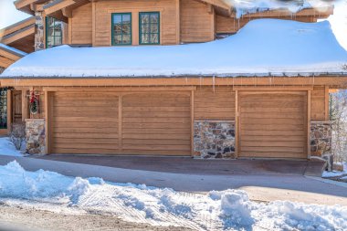 Park City Utah 'taki evi. Karlı çatısı ve garajın girişinde buz saçakları var.