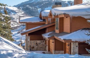 Park City Utah 'ta kış aylarında kar ve buz saçakları olan bir ev.