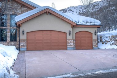 Park City Utah 'ta taş duvarlı bir eve bağlı bir garaj cephesi.