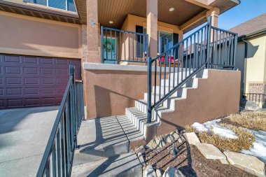 Merdivenleri olan ev girişi, çelenkle birlikte açık veranda ve kapı girişine gidiyor.