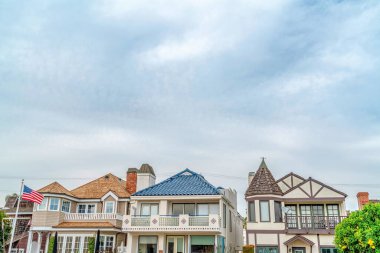 Long Beach California 'da bulutlu gökyüzüne karşı ön balkonları olan şık evler.