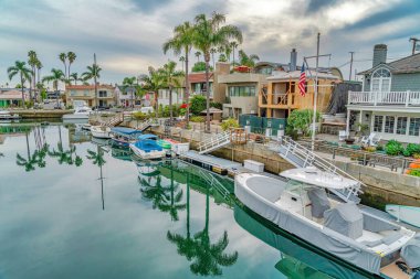 Long Beach sokaklarında palmiye ağaçlarının yansıması olan kanalda tekneler.