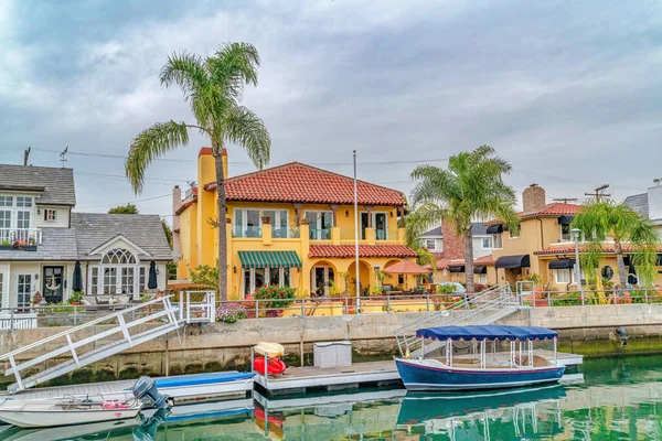 Boten op kanaal langs elegante huizen aan het water in een resort als de buurt — Stockfoto