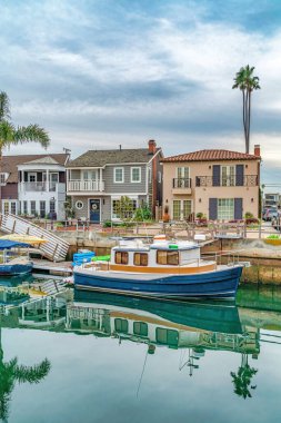 Long Beach California 'daki deniz kıyısındaki evlere karşı tekneler ve rıhtımlar