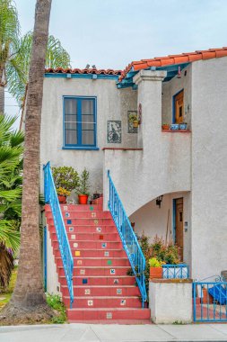 Long Beach California 'daki evin ön cephesinde mavi raylı kırmızı merdivenler.