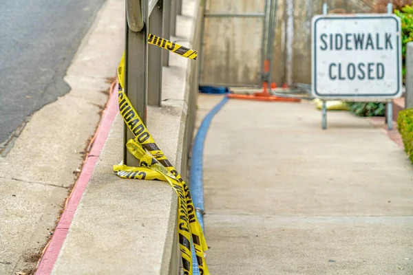 Gele voorzichtigheid tikt op de leuningen van een weg naast een stoep in Long Beach — Stockfoto