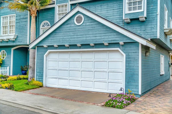 Casa con pared exterior azul y techo a dos aguas garaje adjunto con puerta blanca — Foto de Stock