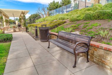 Bench on park pathway in the scenic neighborhood of Huntington Beach California