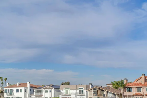 Waterkant huizen onder pittoreske skyscape van blauwe lucht en gezwollen grijze wolken — Stockfoto