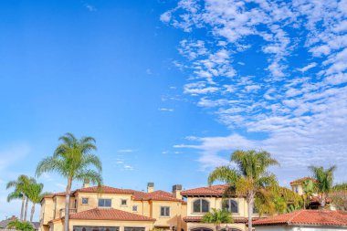 Blue sky with clouds with home and palm trees in Huntington Beach California