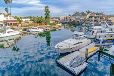 Yachts on private docks of houses in the luxurious Huntington Beach community