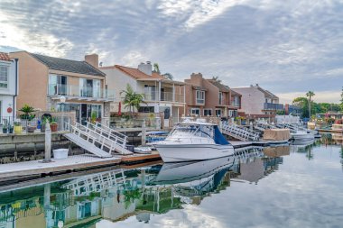 Homes with private docks on water that reflects overcast sky in Huntington Beach