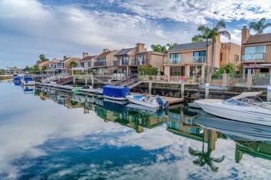 Amazing waterfront landscape with houses docks and boats under cloudy blue sky