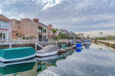 Boats on docks of canal along seaside houses in Huntington Beach Califonia