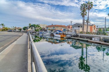 Road and canal with waterfront homes in scenic neighborhood of Huntington Beach