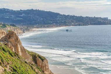 San Diego California 'da dağlarla çevrili bir kıyı şeridi ile okyanustaki iskele.