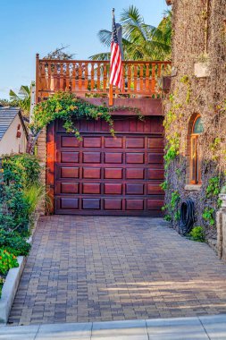 Balkon ve ABD bayrağı, San Diego California 'daki evin kahverengi kapısının üzerinde.