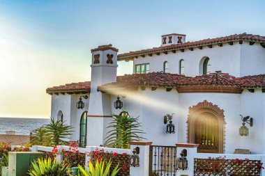 San Diego 'da okyanusa ve gökyüzüne bakan verandalı ve kemerli pencereli beyaz bir ev.