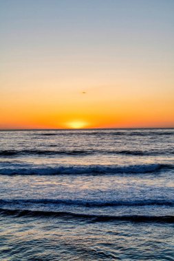 Okyanus ve dalgalar ve turuncu güneş ufuk çizgisinde San Diego California 'da gün batımında