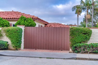 Kahverengi kapı ve beyaz tuğla çit San Diego 'da kırmızı kiremit çatı karşı