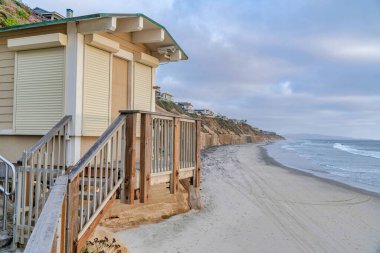 San Diego California 'da kumlu sahildeki deniz manzaralı ve bulutlu gökyüzü manzaralı sahil evi