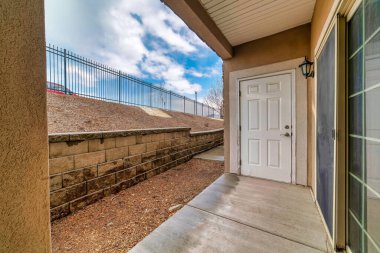 Beyaz ahşap giriş kapısı ve evin dışındaki cam sürgülü kapı.