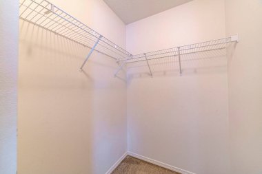 Beyaz duvarda tel askısı olan boş bir depo odası.