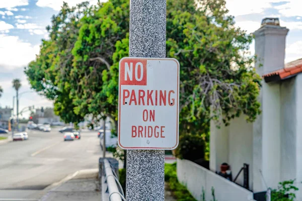 No Parking On Bridge sign close up against road in Huntington Beach California