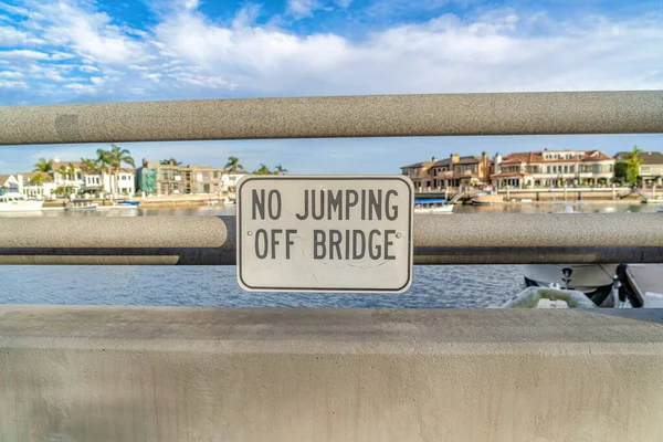 No hay señal de puente de salto con casas frente al mar y el fondo nublado cielo — Foto de Stock