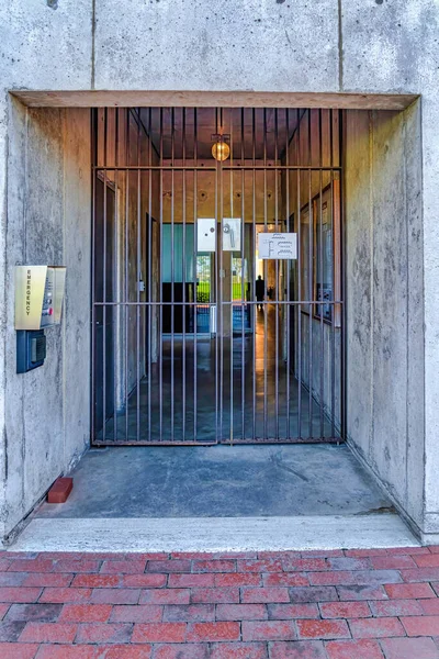 Painel de segurança e portão de metal fechado na entrada do edifício de concreto da escola — Fotografia de Stock
