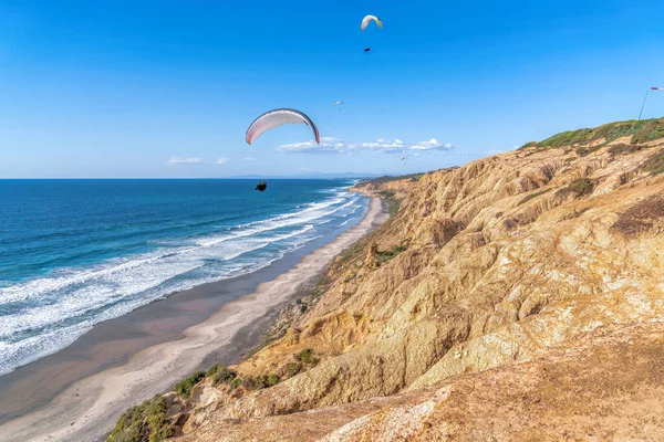 Paracaidistas volando sobre la playa escénica contra el cielo azul en San Diego California — Foto de Stock