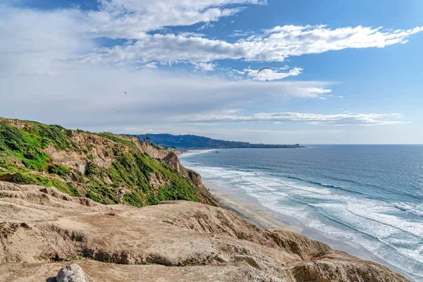 Paracaduter contro il cielo azzurro nuvoloso sulla spiaggia panoramica di San Diego California — Foto Stock