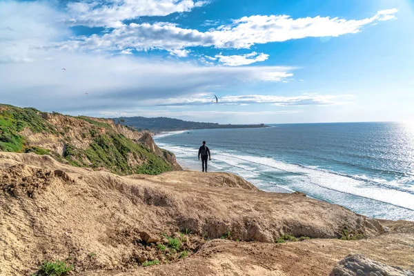 Homem na montanha rochosa com vista para o oceano e céu azul nublado em San Diego CA — Fotografia de Stock